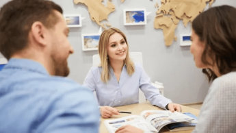 Turystyka i rekreacja | Uniwersytet WSB Merito Gdynia: Kobieta pokazuje parze katalog w biurze podróży.