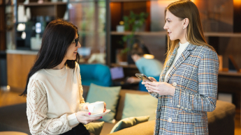 Dwie kobiety rozmawiają w przestrzeni kawiarni 