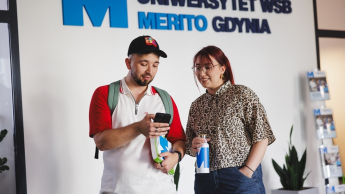 Studenci przy logotypie Merito