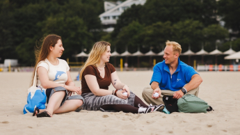 Bezpieczeństwo finansowe i celno-skarbowe państwa | Studia I stopnia w Gdyni | Uniwersytet WSB Merito Gdynia: Studenci siedzą na piasku na plaży