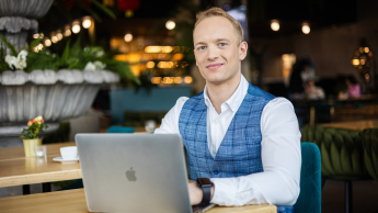 Student w biznesowym stroju w kawiarni przy laptopie