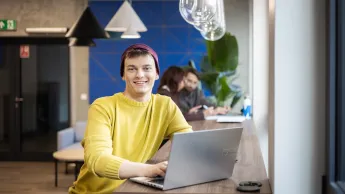 Planowanie produkcji – nowoczesne   narzędzia: SAP S/4HANA, Siemens Opcenter APS | Studia podyplomowe w Gdyni | Uniwersytet WSB Merito Gdynia: Student przy laptopie w strefie studenta