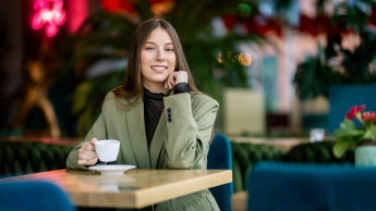 Studentka w kawiarni z kawą w ręku 