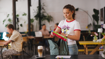 Studentka pakuje plecak w kawiarni