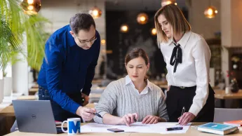 Studia menedżerskie | Studia podyplomowe w Gdyni | Uniwersytet WSB Merito Gdynia: Grupa pracująca nad zagadnieniem przy notatkach i laptopie