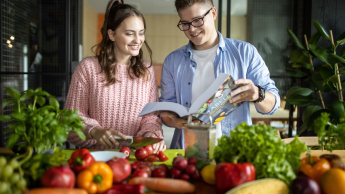 Wyniki wyszukiwania | Uniwersytet WSB Merito Gdynia: Studentka i student z książką otoczeni warzywami o owocami