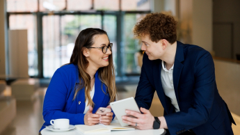 AI Developer & Vibe Coding – nowoczesne środowiska programowania z AI | Studia podyplomowe w Gdyni | Uniwersytet WSB Merito Gdynia: Rozmowa kobiety i mężczyzny przy stoliku