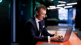 AI Product Manager | Studia podyplomowe w Gdyni | Uniwersytet WSB Merito Gdynia: Mężczyzna w garniturze przy laptopie