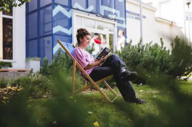 Nasz budynek | Uniwersytet WSB Merito Gdynia: Studentka na leżaku przed budynkiem 