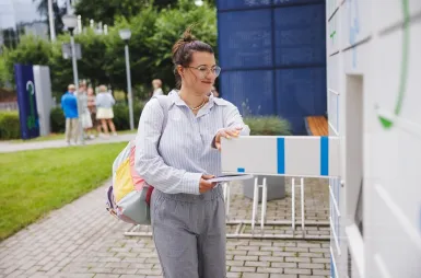 ABC studenta | Uniwersytet WSB Merito Gdynia: Studentka wyjmuje książki z książkomatu