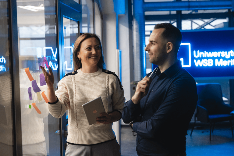 Zielone technologie i sztuczna inteligencja: informatyka dla zrównoważonego rozwoju | Studia podyplomowe w Gdyni | Uniwersytet WSB Merito Gdynia: Kobieta i mężczyzna na Uniwersytecie WSB Merito podczas rozmowy biznesowej