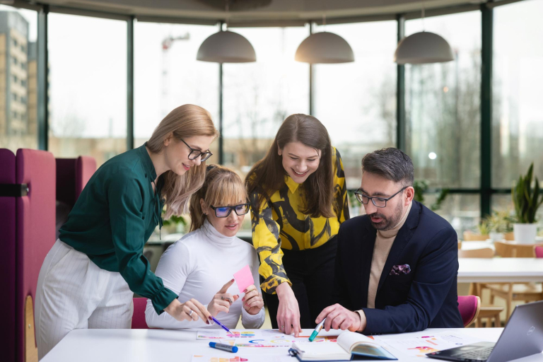 Rankingi i akredytacje | Uniwersytet WSB Merito Gdynia: grupa-osob-przy-stole-pracujaca-nad-projektem