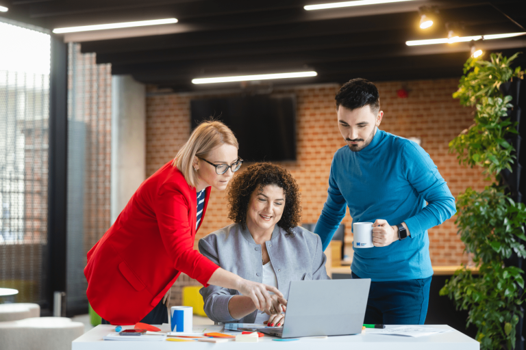 Władze uniwersytetu | Uniwersytet WSB Merito Gdynia: Słuchacze współpracujący przy laptopie i omawiający projekt - dwie kobiety i mężczyzna