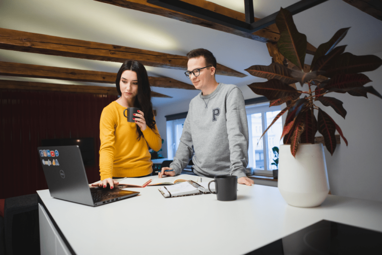 Centrum Badań i Komercjalizacji   | Uniwersytet WSB Merito Gdynia: Student i studentka omawiają wspólny projekt przy laptopie