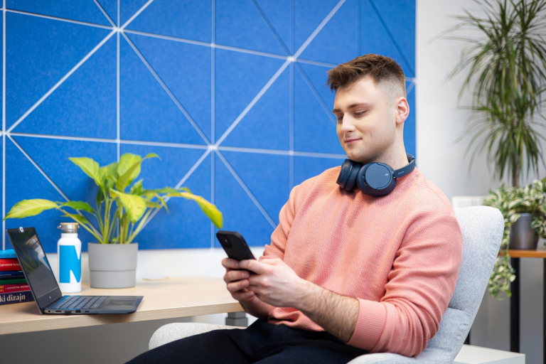 Informatyka | Studia I stopnia w Gdyni | Uniwersytet WSB Merito Gdynia: Student przy komputerze i urządzeniu mobilnym