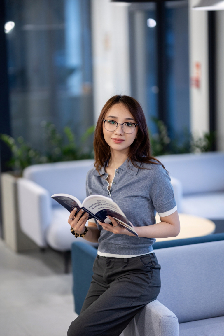 Psychoneuroimmunologia (PNI) | Studia podyplomowe w Gdyni | Uniwersytet WSB Merito Gdynia: Studentka w holu z książką