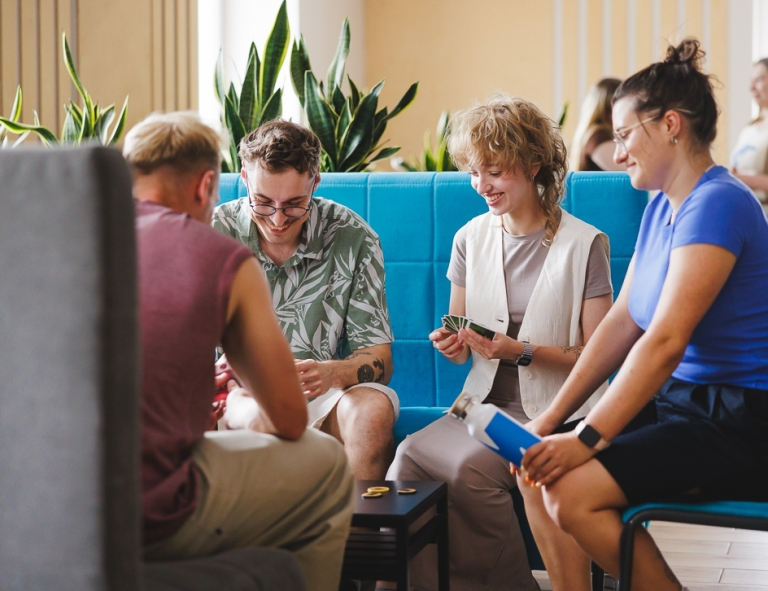 Cykl bezpłatnych warsztatów i wykładów dla uczniów szkół średnich | Aktualności | Uniwersytet WSB Merito Gdynia: Studenci w strefie studenta grają w karty podczas przerwy