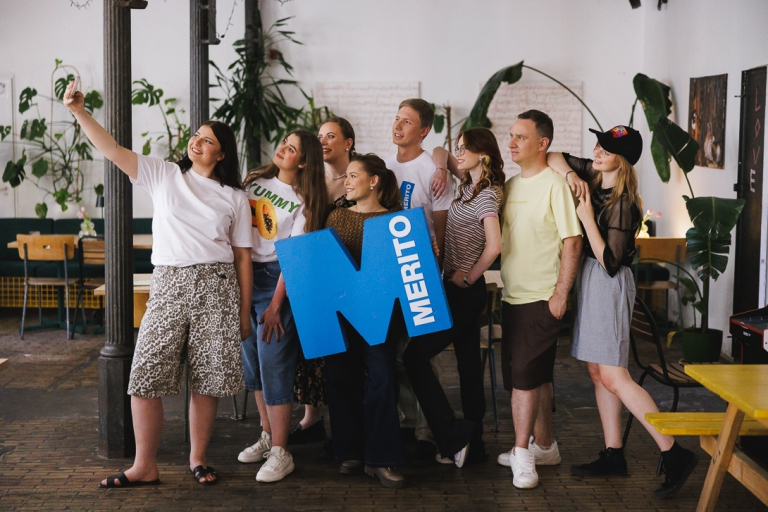 Studia jednolite magisterskie w Gdyni | Uniwersytet WSB Merito Gdynia: Zdjęcie grupowe studentów w kawiarni z logiem 