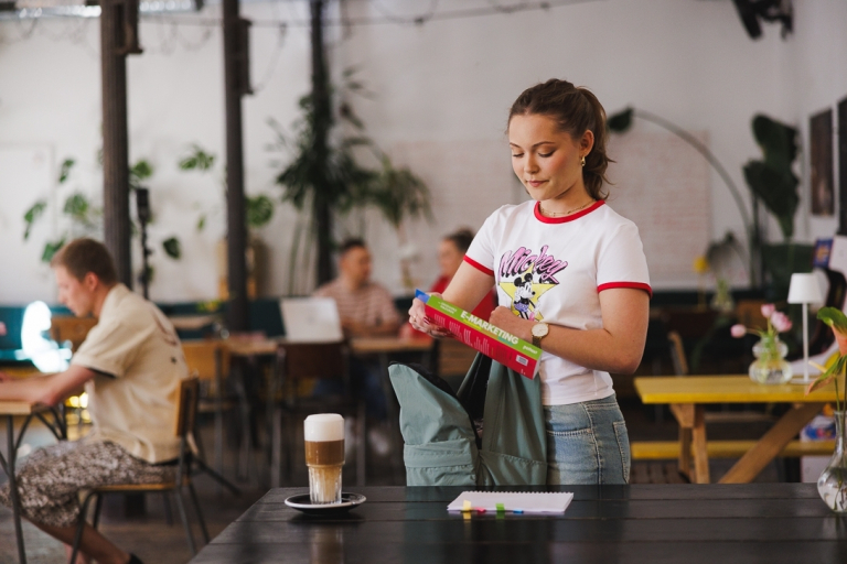 STEAM i sztuczna inteligencja w edukacji | Studia podyplomowe w Gdyni | Uniwersytet WSB Merito Gdynia: Studentka pakuje plecak w kawiarni