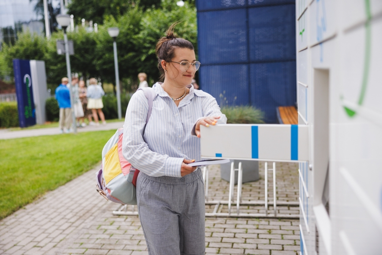 Technologie sztucznej inteligencji | Studia I stopnia w Gdyni | Uniwersytet WSB Merito Gdynia: Studentka wyjmuje książki z książkomatu