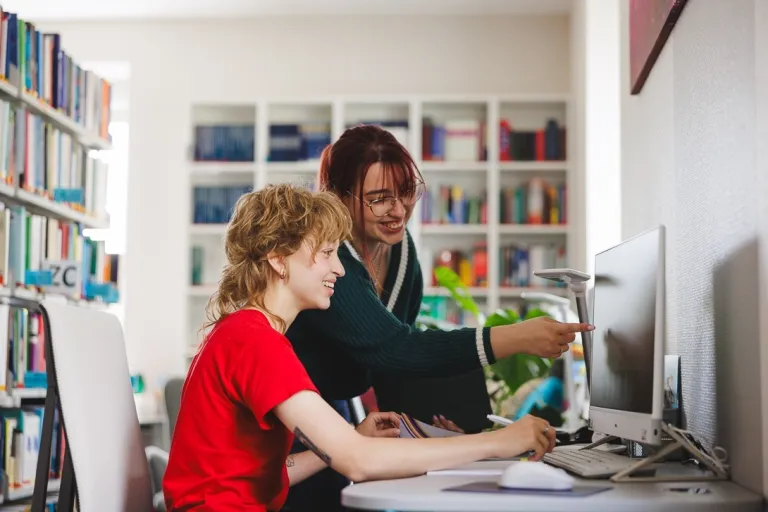 Samorząd studencki | Uniwersytet WSB Merito Gdynia: Studentki przy monitorze w bibliotece