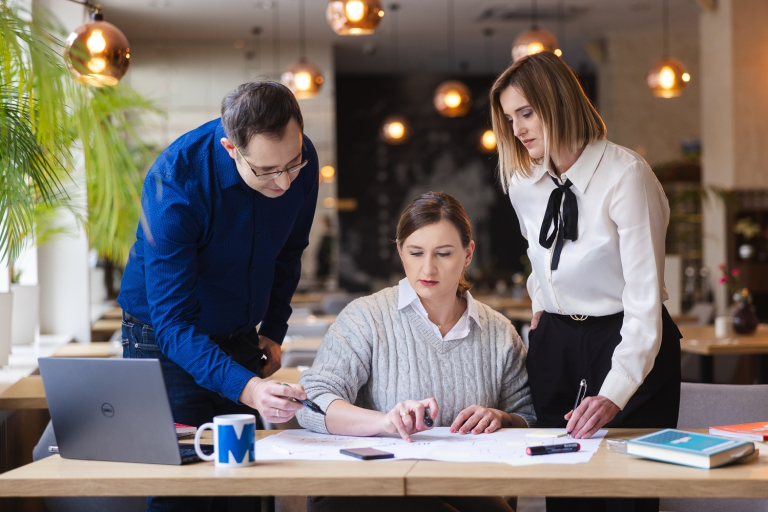 Negocjacje w biznesie - certyfikat Franklin University | Studia podyplomowe w Gdyni | Uniwersytet WSB Merito Gdynia: Grupa pracująca nad zagadnieniem przy notatkach i laptopie