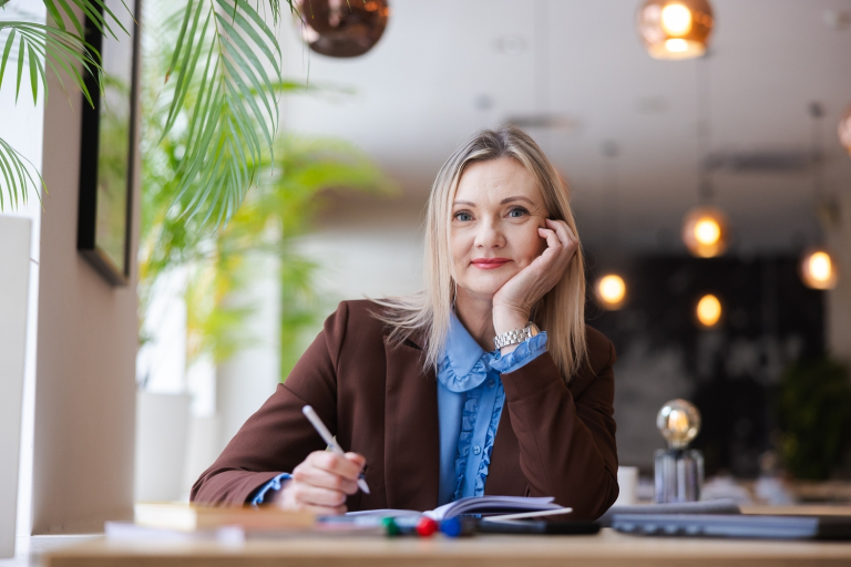 Zarządzanie jakością i produkcją w branży produkcyjnej | Studia podyplomowe w Gdyni | Uniwersytet WSB Merito Gdynia: Portret kobiety przy notatkach