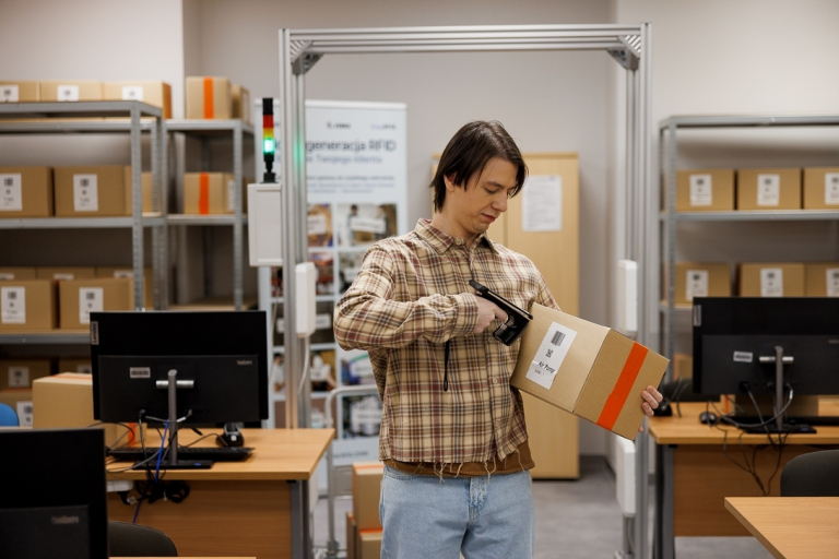 Logistyka międzynarodowa | Studia I stopnia w Gdyni | Uniwersytet WSB Merito Gdynia: Student w magazynie z kartonami 