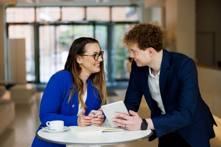 Analiza biznesowa wspomagana AI | Studia podyplomowe w Gdyni | Uniwersytet WSB Merito Gdynia: Rozmowa kobiety i mężczyzny przy stoliku