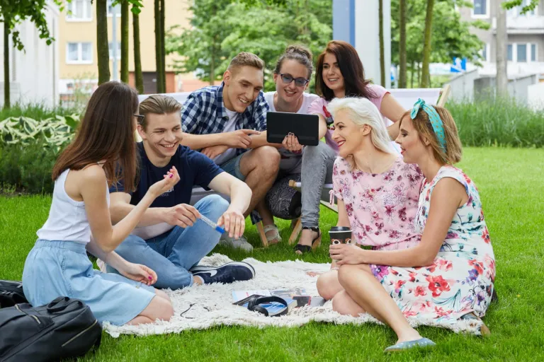 Pedagogika opiekuńczo-wychowawcza z elementami edukacji międzykulturowej | Studia I stopnia w Gdyni | Uniwersytet WSB Merito Gdynia: Studenci na trawie przed budynkiem
