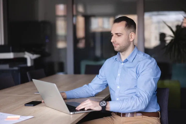 Projektowanie gier komputerowych | Studia I stopnia w Gdyni | Uniwersytet WSB Merito Gdynia: mężczyzna siedzi przy biurku i pracuje na laptopie