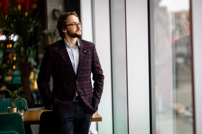 Student przy oknie w garniturze