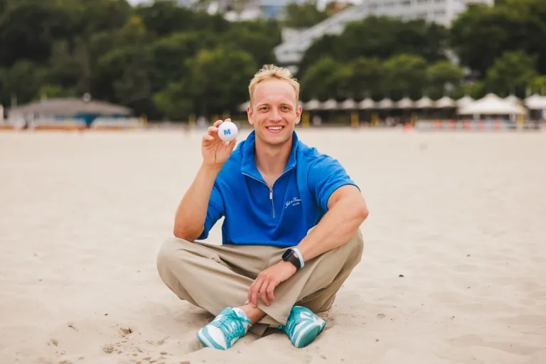 Student na plaży w Gdyni z piłęczką Merito w dłoni