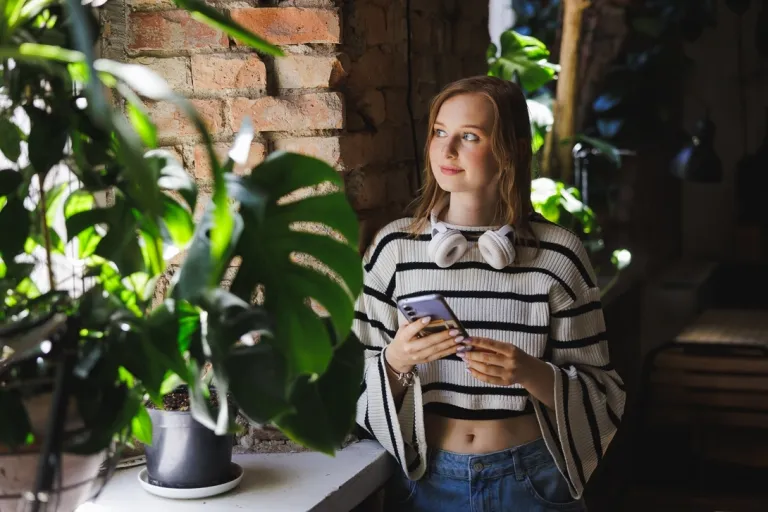 Gospodarowanie nieruchomościami | Studia I stopnia w Gdyni | Uniwersytet WSB Merito Gdynia: Studentka przy oknie i parapecie pełnym kwiatów