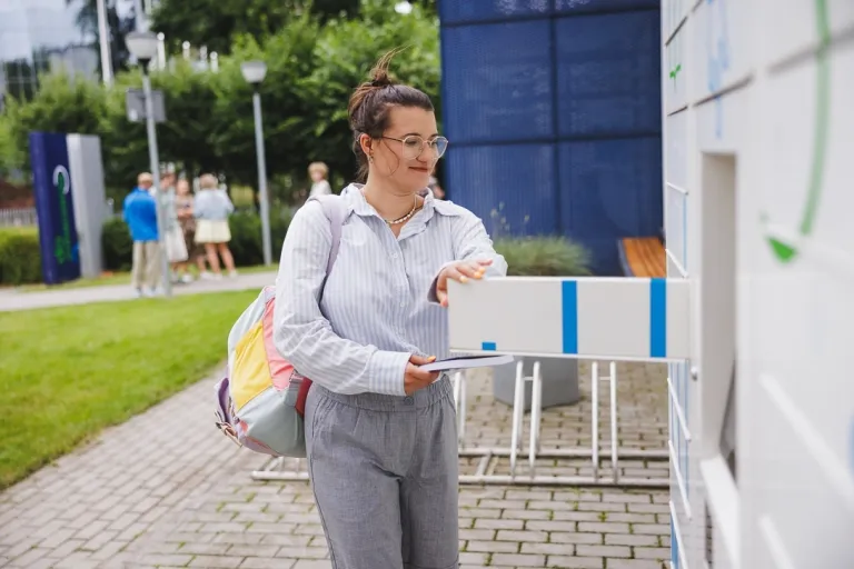 Bezpieczeństwo morskie i ochrona portów | Studia I stopnia w Gdyni | Uniwersytet WSB Merito Gdynia: Studentka wyjmuje książki z książkomatu