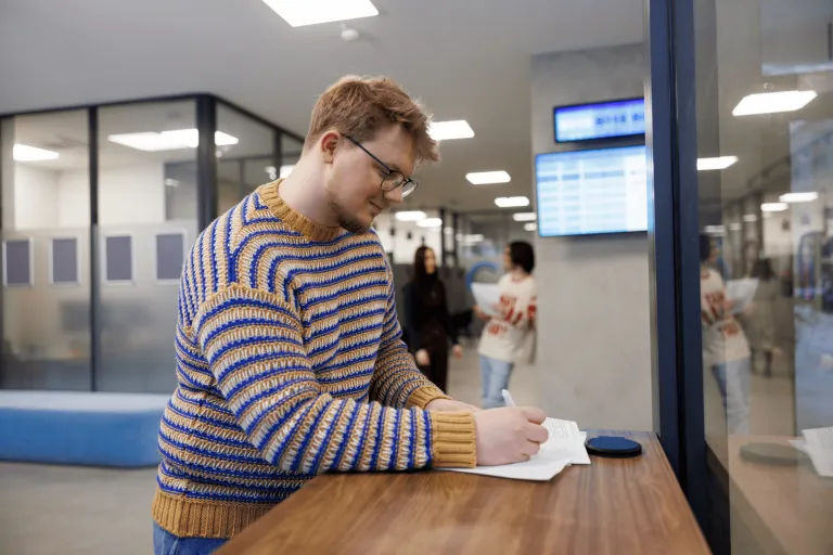 Informatyka | Studia I stopnia w Gdyni | Uniwersytet WSB Merito Gdynia: Zdjęcie studenta podpisującego dokumenty