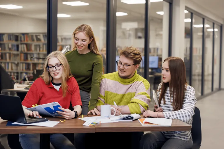 Studenci przy biurku pracują razem nad zagadnieniem