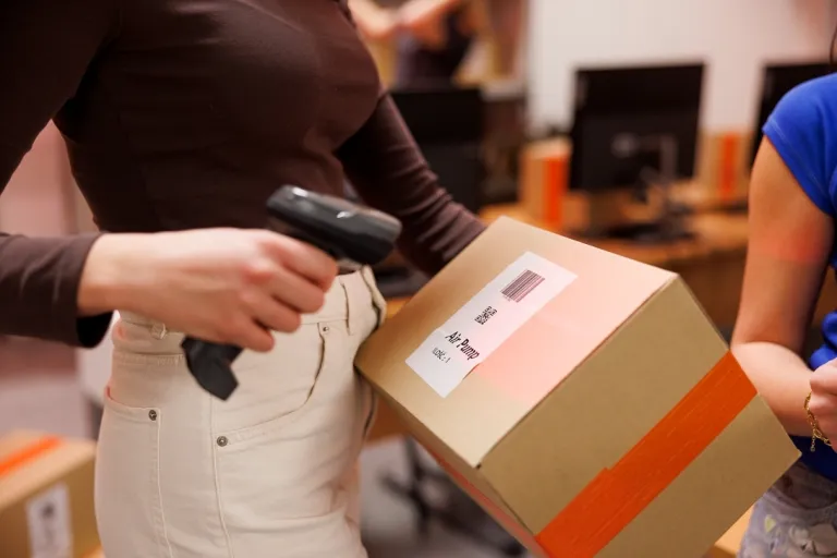 Transport Spedycja Logistyka | Studia I stopnia w Gdyni | Uniwersytet WSB Merito Gdynia: Studentka skanuje kod QR na kartonie