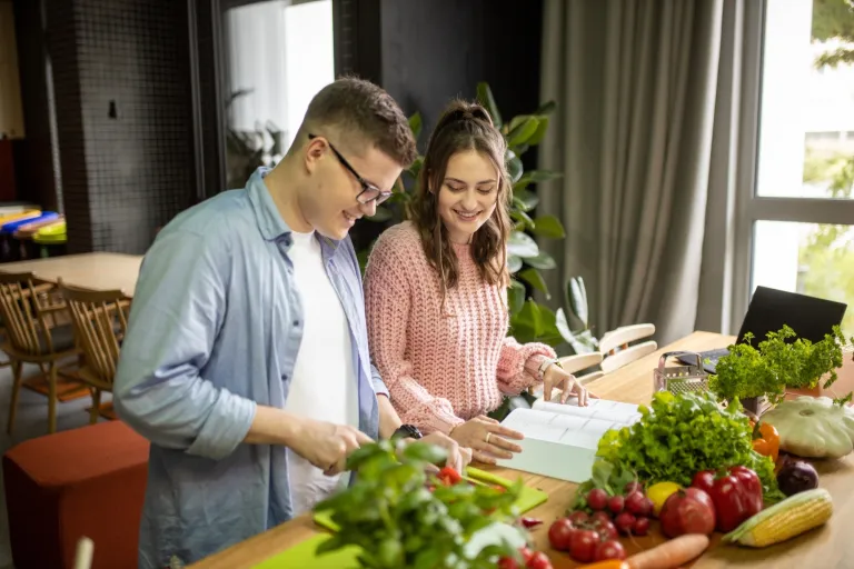 Wyniki wyszukiwania | Uniwersytet WSB Merito Gdynia: Student i studentka nad książką, wokół warzywa i owoce