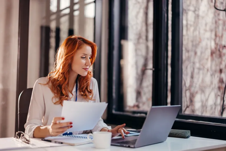 Prompting i optymalizacja systemów AI | Uniwersytet WSB Merito Gdynia: Kobieta o rudych włosach przy laptopie