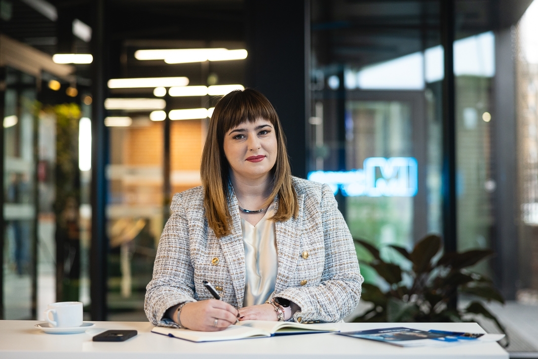 Uczestniczka studiów MBA siedzi przy stole z dokumentami- Uniwersytety WSB Merito