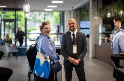 Poradniki - dzielimy się wiedzą | Uniwersytet WSB Merito: Uczestnik i uczestniczka konferencji z widocznym logotypem Merito na torbie