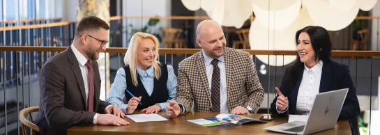 Studia MBA i EMBA | Uniwersytet WSB Merito: czterech uczestników MBA siedzi przy stole i rozmawia- Uniwersytety WSB Merito
