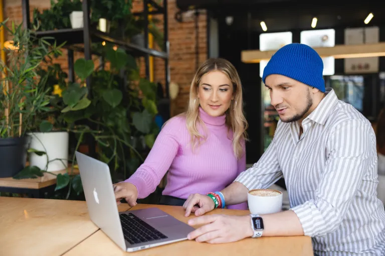 Jak sztuczna inteligencja zmienia marketing? | Blog "okiem praktyków" | Uniwersytet WSB Merito: Kobieta i mężczyzna prowadzący rozmowę przy laptopie