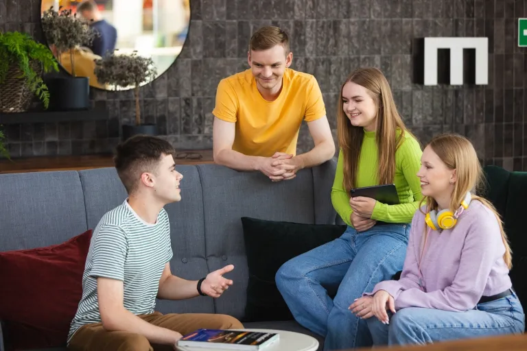 Slang studencki, czyli słownik gwary uczelnianej | Uniwersytet WSB Merito: Grupa ludzi rozmawiająca na kanapie