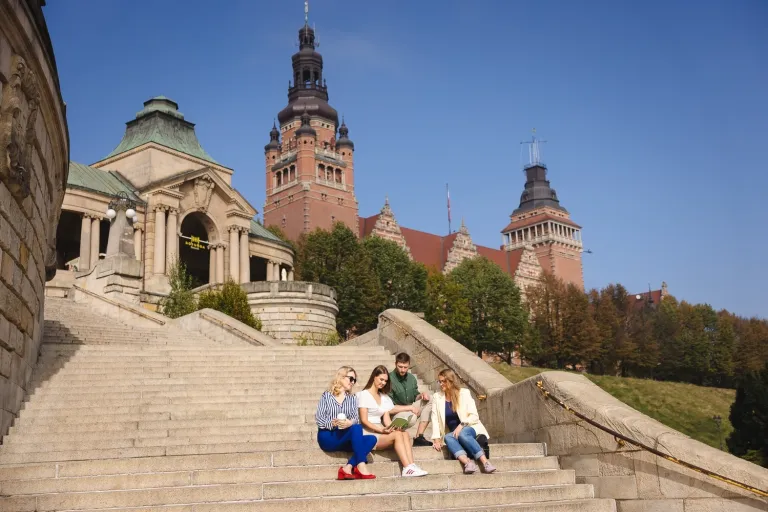 Zaplanuj wakacje marzeń | Blog "okiem praktyków" | Uniwersytet WSB Merito: Grupa ludzi rozmawiająca na schodach na świeżym powietrzu