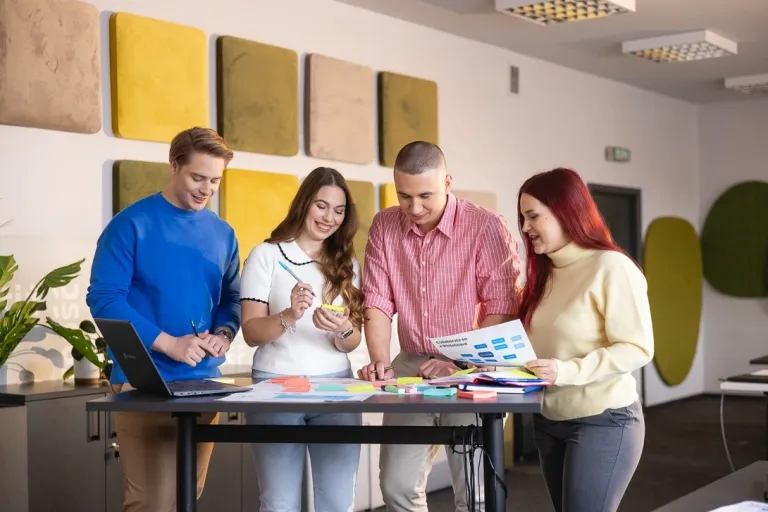 Studia online. Czy się sprawdziły? Jak ewoluowały w studia hybrydowe? | Uniwersytet WSB Merito: Cztery osoby stojące przy stole