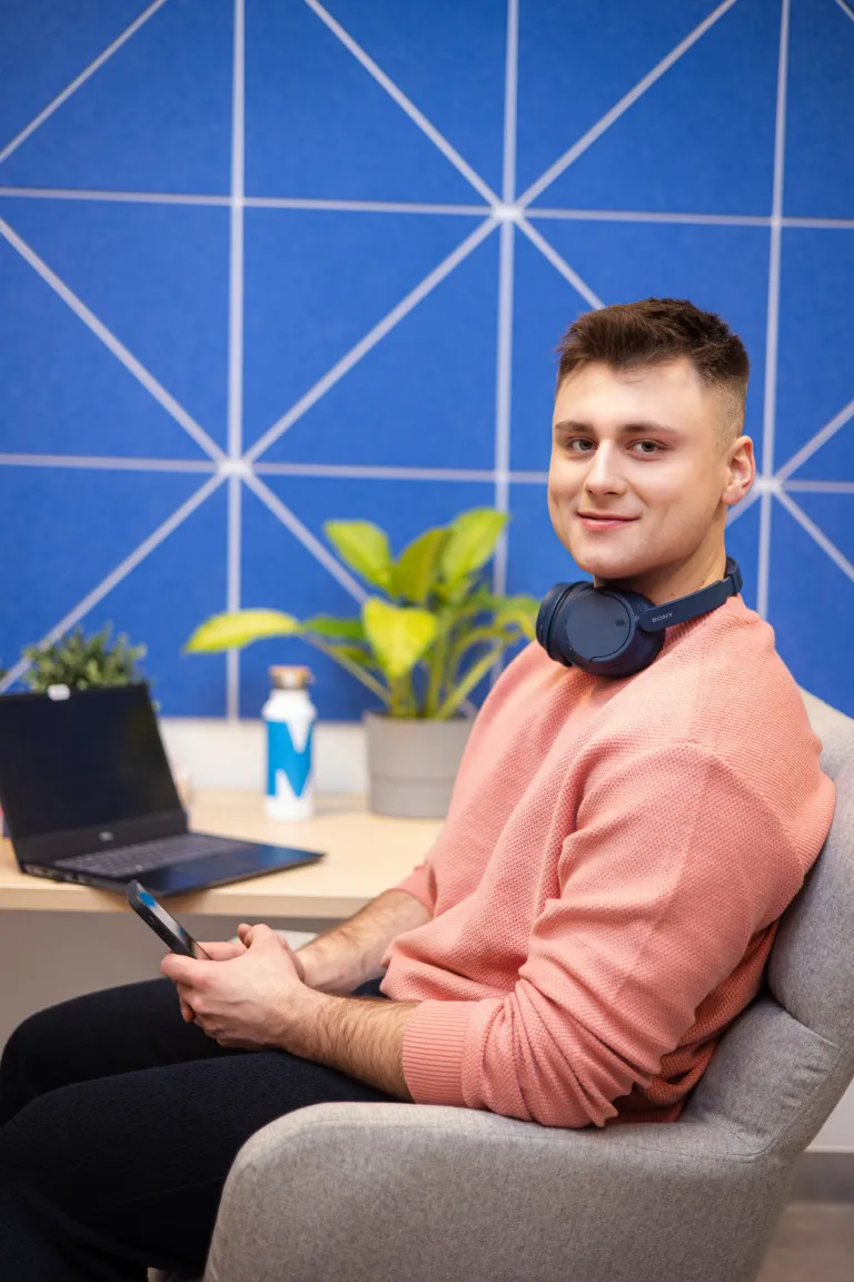 Nowa era cyfrowych inwestycji: NFT | Blog "okiem praktyków" | Uniwersytet WSB Merito: Chłopak z laptopem w niebieskim