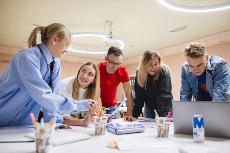 Jak wyglądają pierwsze dni na studiach? Poradnik dla nowych studentów | Uniwersytet WSB Merito: Grupa osób pracująca przy stole