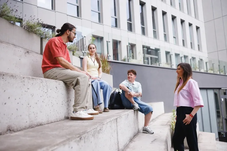 Czy studia przygotują mnie do pracy? Czy wyższe wykształcenie nadal gwarantuje dobrą pracę? | Uniwersytet WSB Merito: Grupa ludzi siedząca na schodach
